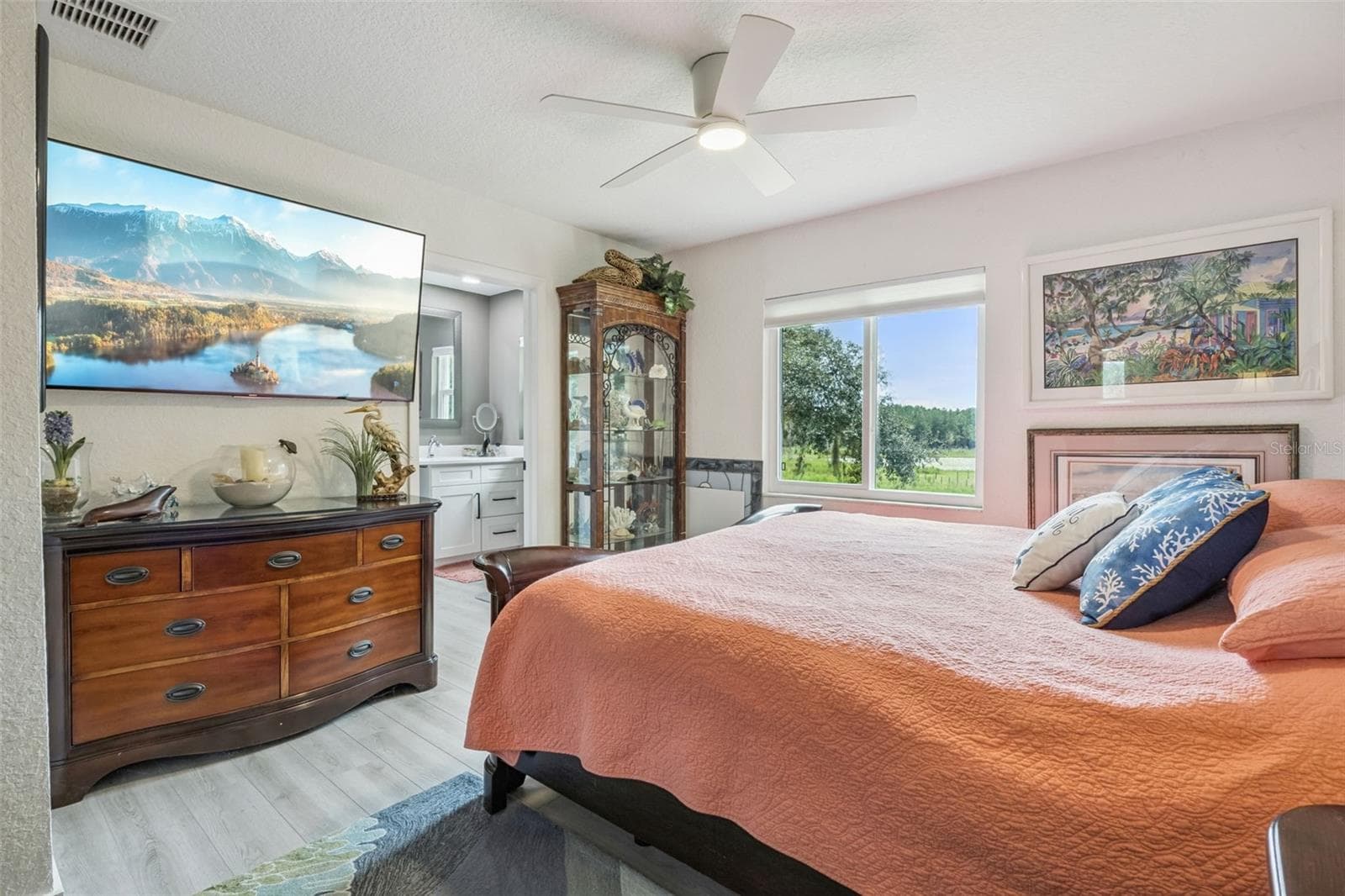 Generously sized primary bedroom with direct en-suite bath access and sweeping pastoral views that stretch for miles. - 1476 SPRING LAKE RD, FRUITLAND PARK