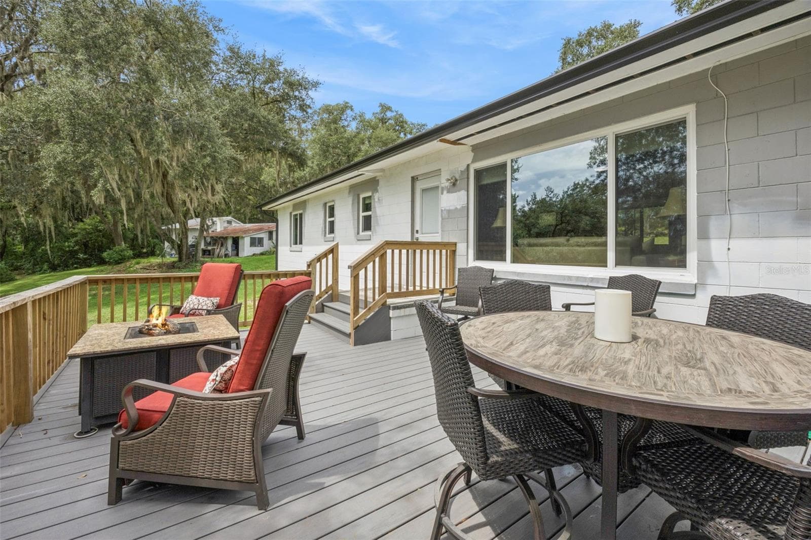 Spacious rear deck with room for outdoor dining and fireside lounging, overlooking the peaceful backyard. - 1476 SPRING LAKE RD, FRUITLAND PARK