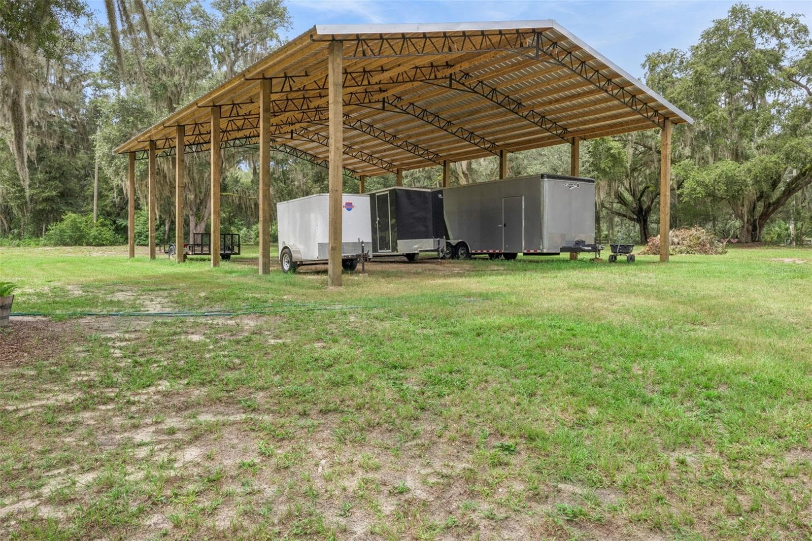 Covered pole barn provides protected storage for equipment, vehicles, boats, or RVs. - 1476 SPRING LAKE RD, FRUITLAND PARK
