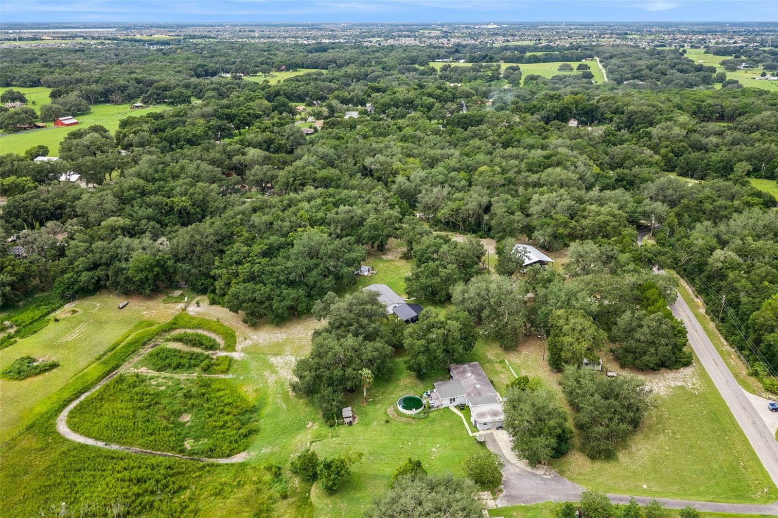 Stunning aerial view revealing the full scope of this remarkable property and its lush, oak-canopied setting. - 1476 SPRING LAKE RD, FRUITLAND PARK