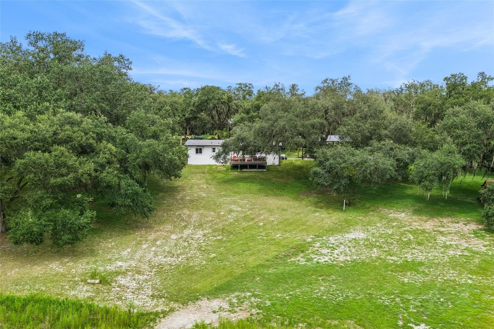 Aerial shot showcasing the property layout, outbuildings, and the incredible natural landscape. - 1476 SPRING LAKE RD, FRUITLAND PARK