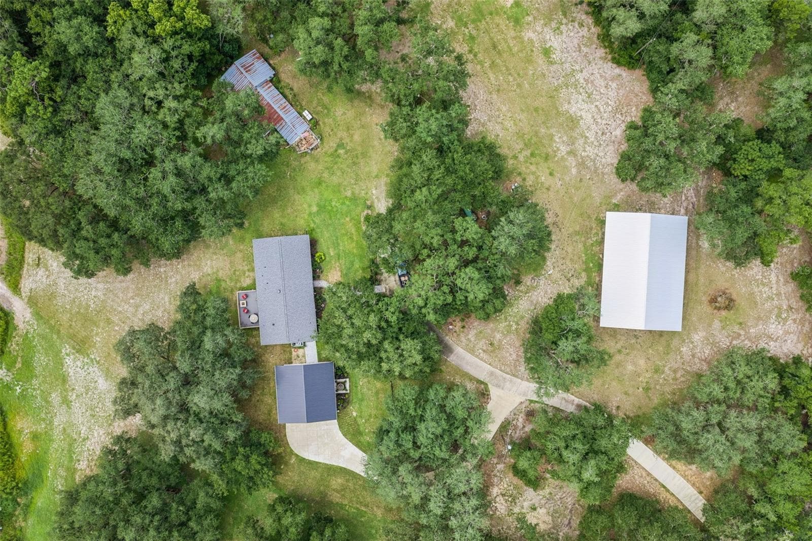 Final aerial perspective showing the surrounding rolling hills, open pastures, and the peaceful Lake County setting. - 1476 SPRING LAKE RD, FRUITLAND PARK