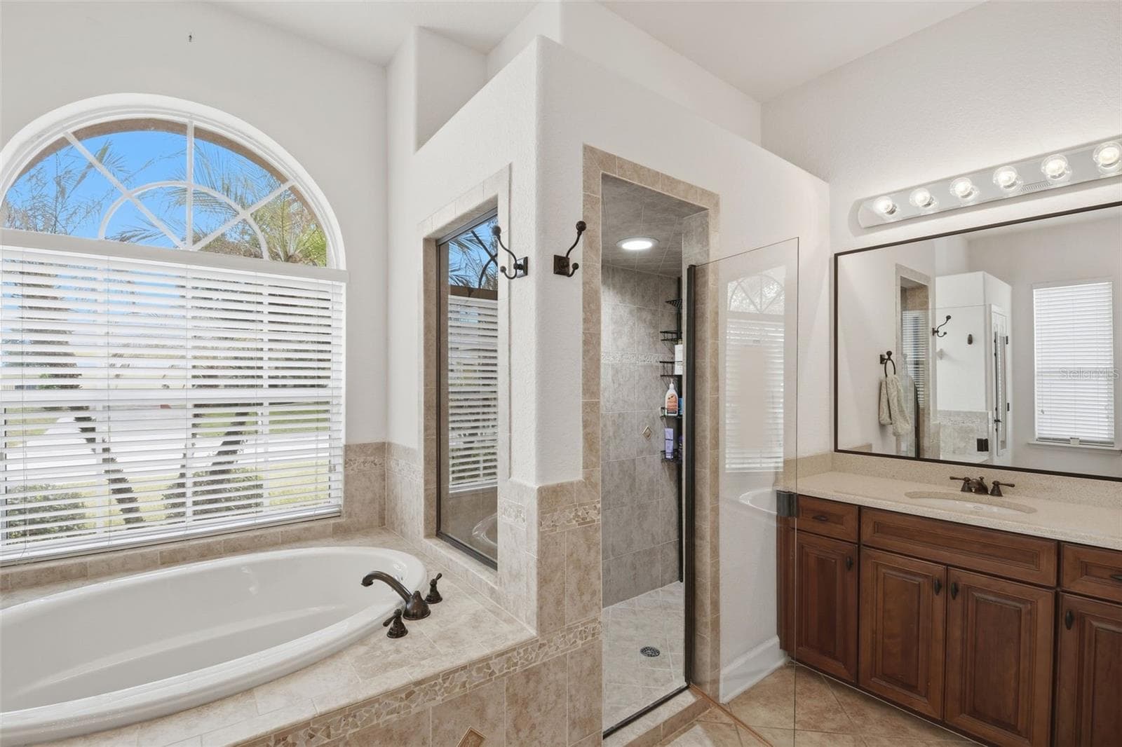 Primary Bedroom – Another angle of the primary suite highlights its generous proportions, high ceiling, natural light, and convenient connection to the adjoining bath area. - 114 VIOLA DR, AUBURNDALE