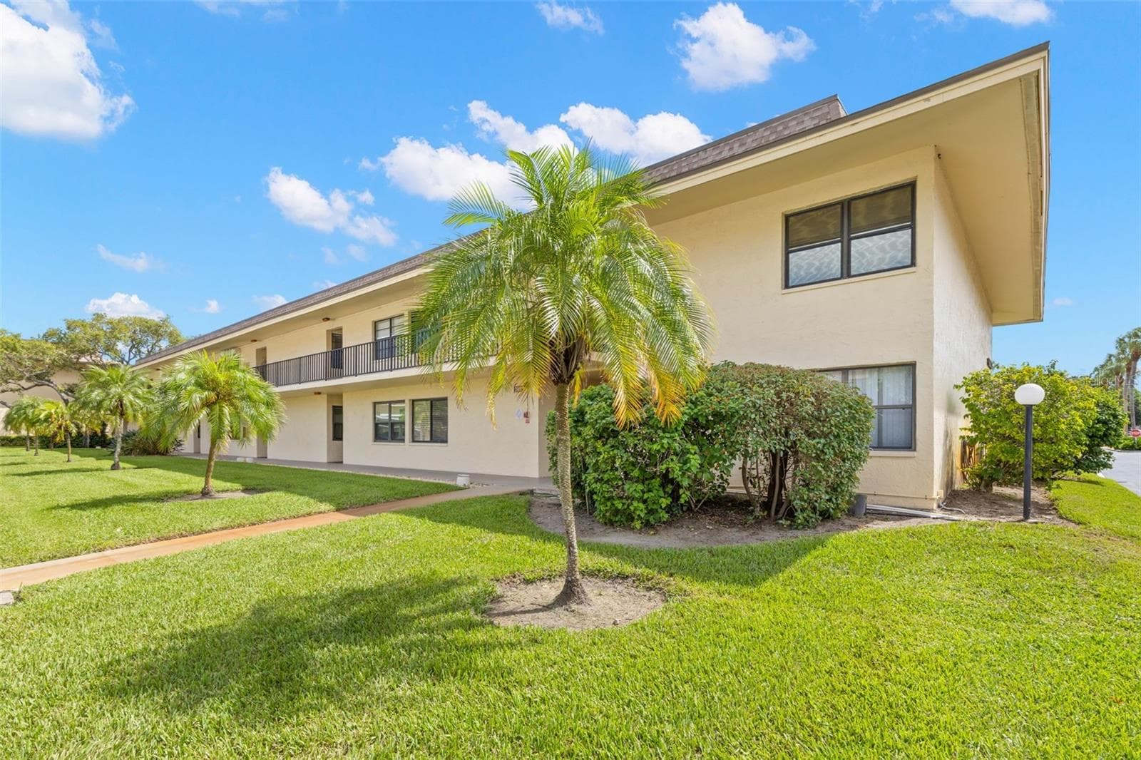 Mature palms, open lawn and landscaped grounds surround Building 3, with a paved walkway leading to the second-floor residences. - 12300 VONN RD #3204, LARGO