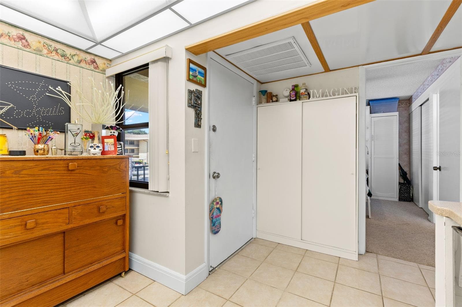 A window beside the front door brings natural light into the entry, where a tall double-door cabinet adds useful storage. Just beyond, a separate opening leads to the second bedroom and bath. - 12300 VONN RD #3204, LARGO