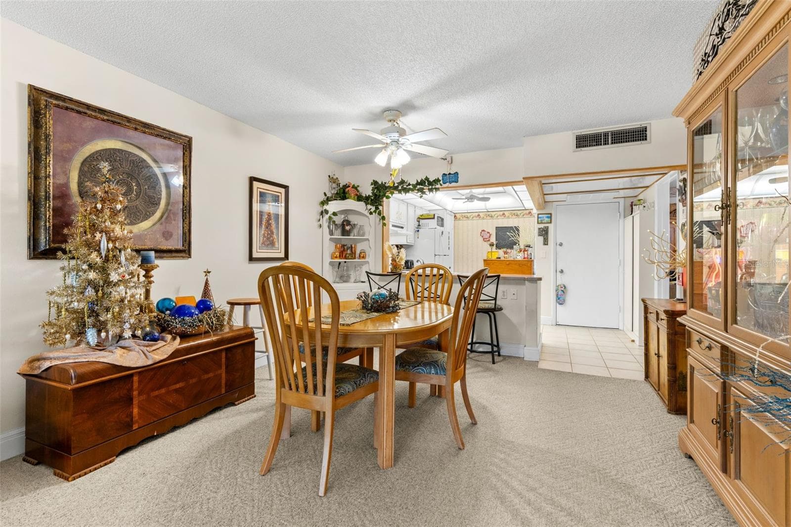 Neutral carpeting and soft wall tones keep the dining area understated, while a ceiling fan adds practical comfort. The open connection to the kitchen keeps the space visually linked without losing its own defined footprint. - 12300 VONN RD #3204, LARGO