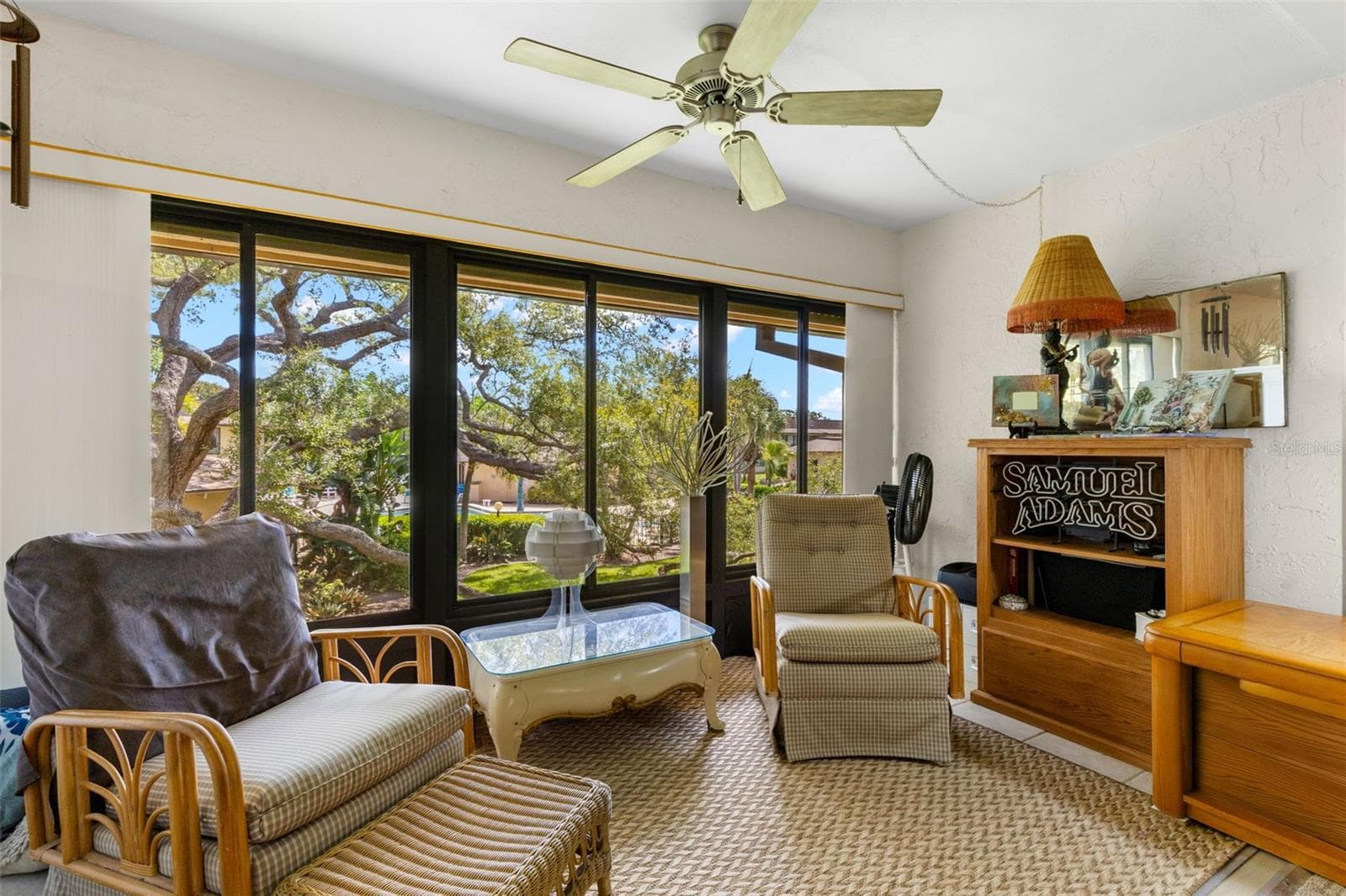 The Florida room has tile flooring, its own ceiling fan and a broad wall of windows overlooking the trees and landscaped grounds. Open to the living room, it adds a separate sitting area without feeling cut off from the rest of the space. - 12300 VONN RD #3204, LARGO