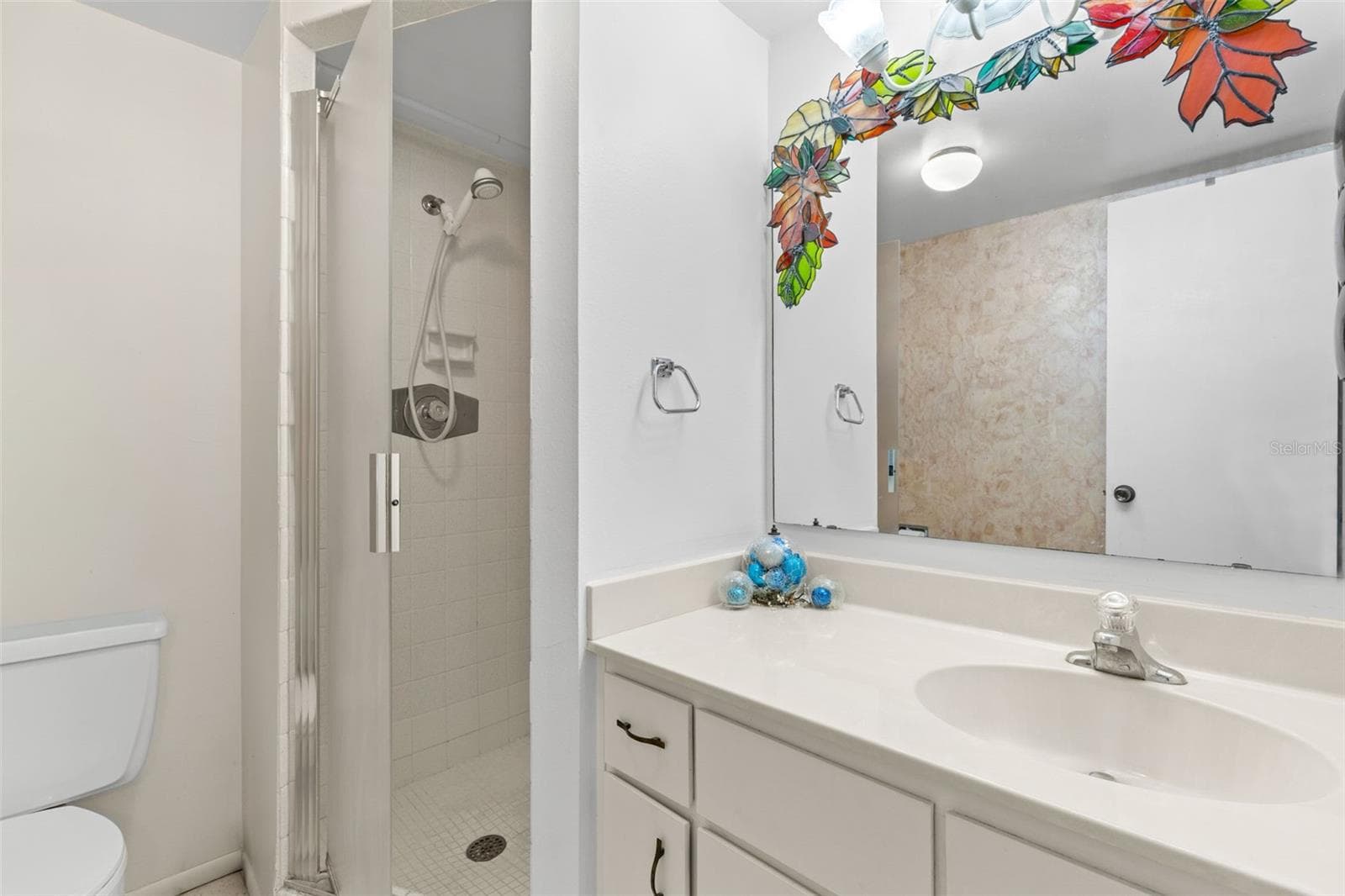 Bedroom 2 has its own ensuite bath with a single-sink vanity, generous counter space and a large wall mirror. The walk-in shower includes a glass door, tiled surround and handheld showerhead. - 12300 VONN RD #3204, LARGO