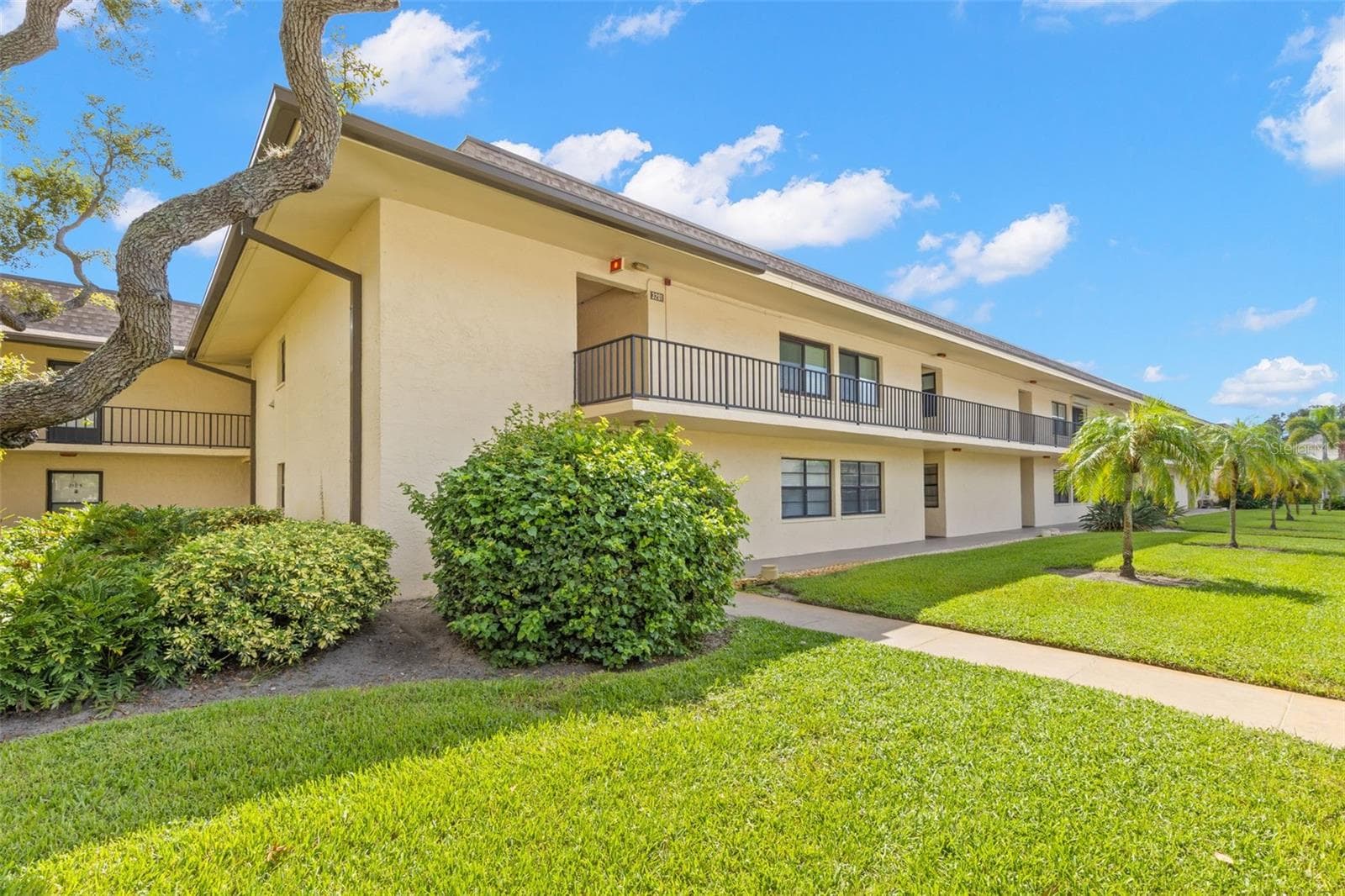 Building 3 is surrounded by open lawn, mature landscaping and palms, with covered walkways along both levels. - 12300 VONN RD #3204, LARGO