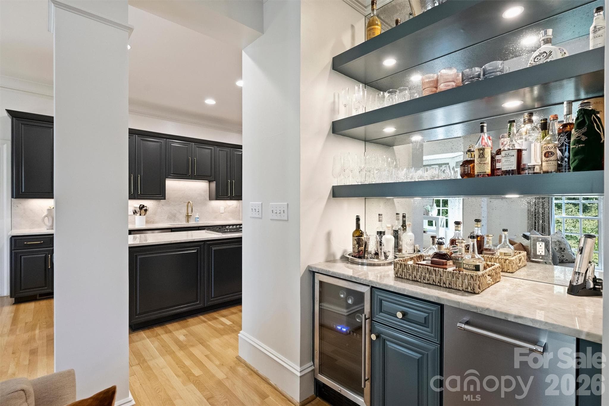 Dry bar was completely transformed with an antique mirror backsplash, custom shelving, a beverage fridge and an ice machine. - 2115 Foxcroft Woods Lane, Charlotte