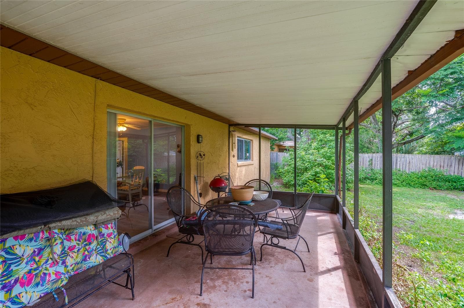 Covered, screened outdoor patio space with concrete flooring and sliding door access to the main interior. - 146 WESTWOOD DR, DAYTONA BEACH