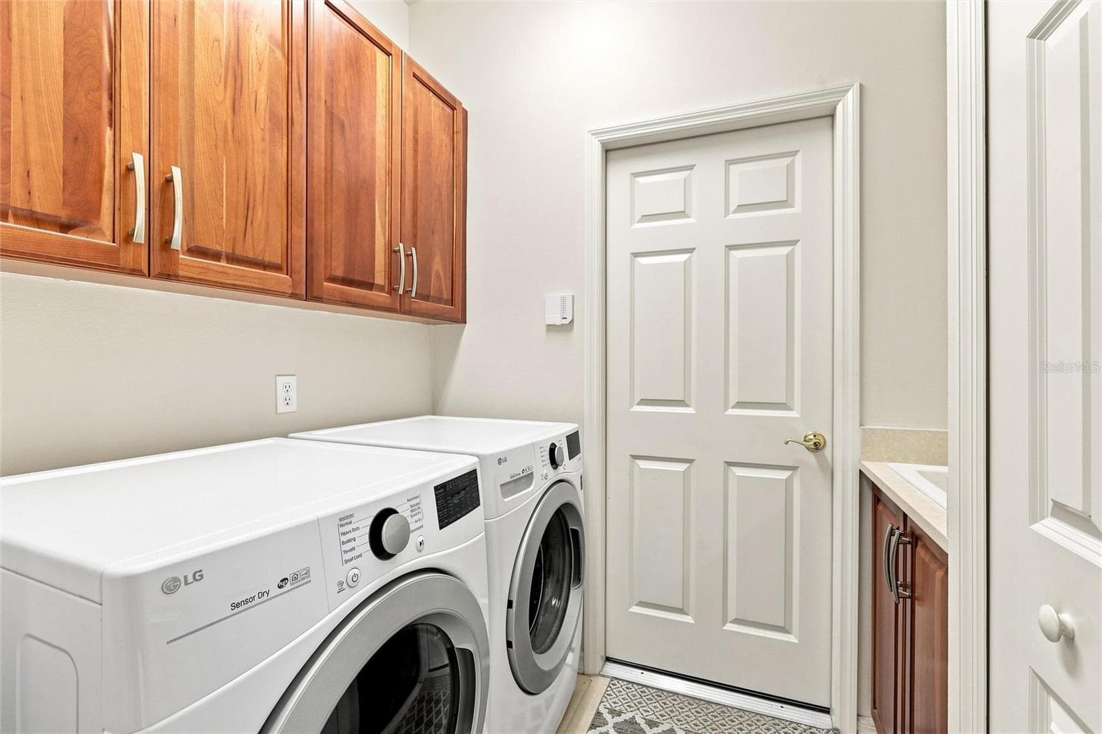 Laundry room with upper and lower cabinets with a deep large sink and utility closet - 1328 THORNAPPLE DR, OSPREY