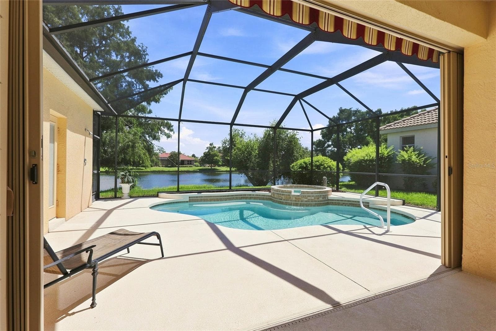 View of pool/spa from family room sliding doors see accordion shutter and awning - 1328 THORNAPPLE DR, OSPREY