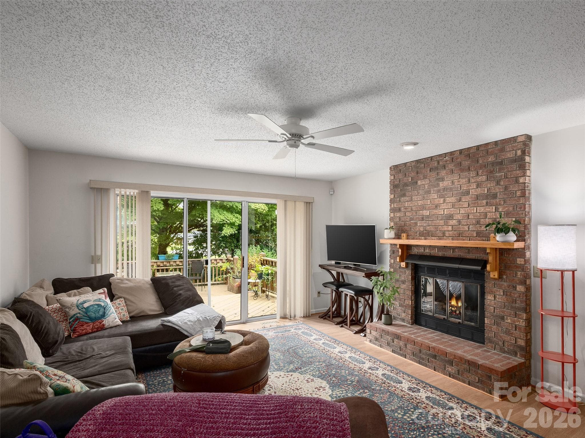 Spacious living room with gas-log fireplace and access to the rear deck at 5 St Andrews Drive in Etowah, NC. - 5 St Andrews Drive, Etowah