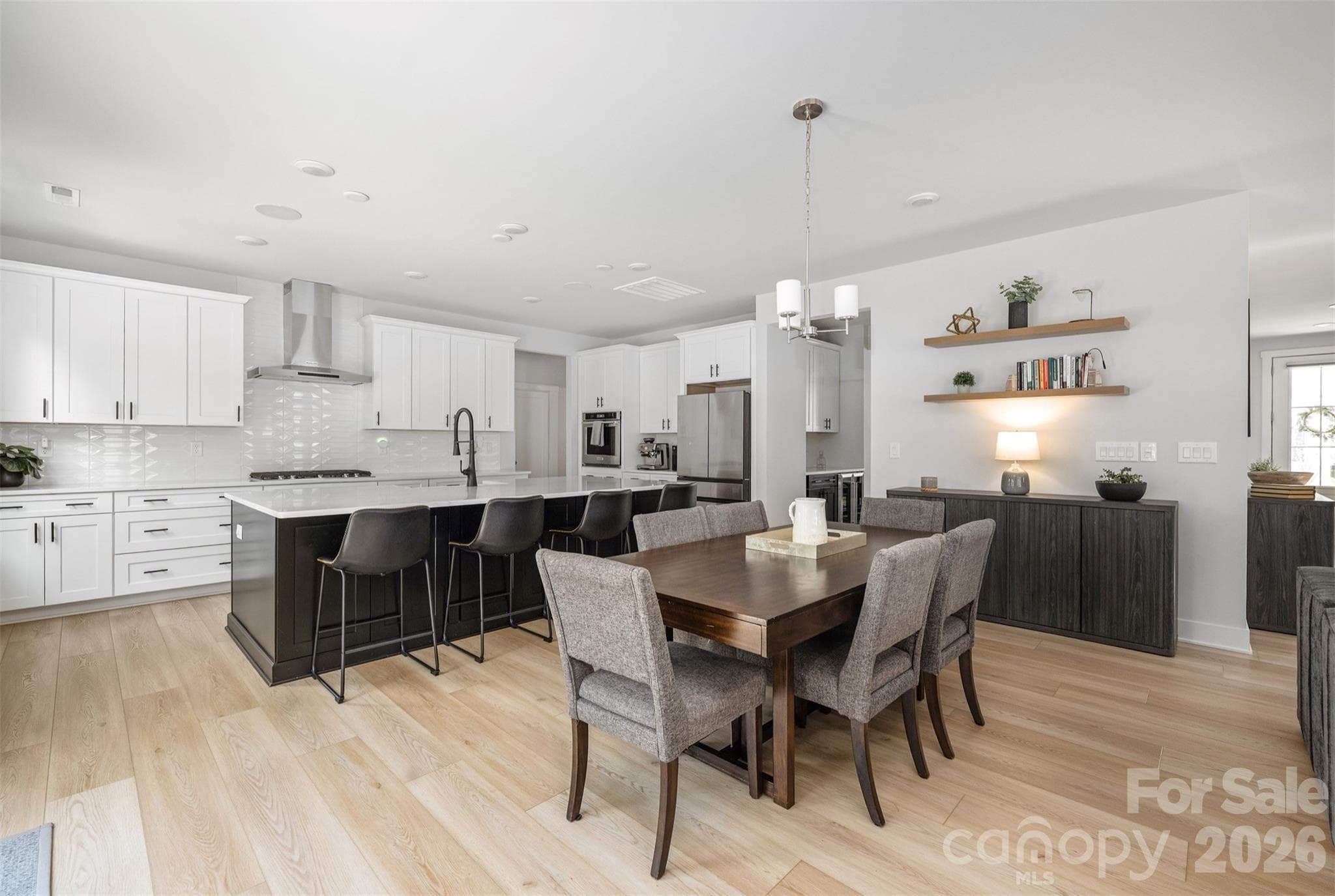 Kitchen with oversized black island, quartz counters, tile backsplash to the ceiling, and KitchenAid appliances - 4320 Tournette Drive, Indian Land