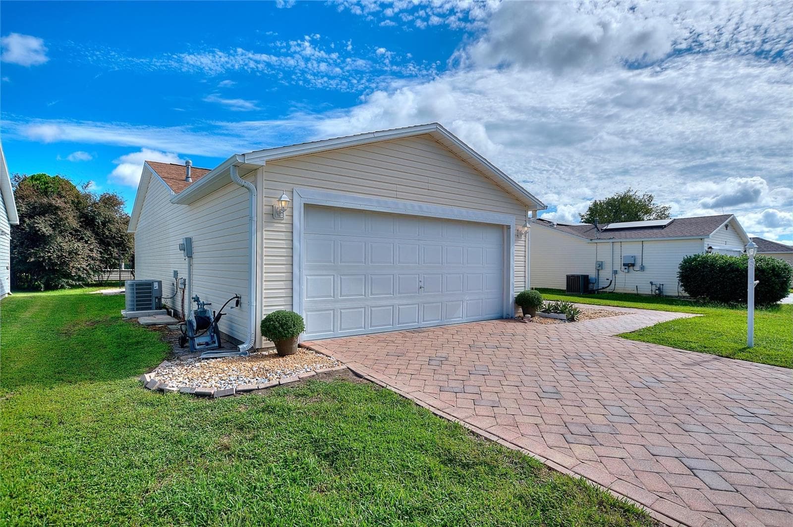 Attached two-car garage with a spacious paver driveway for convenient everyday parking. - 2713 DE LA ROSA ST, THE VILLAGES