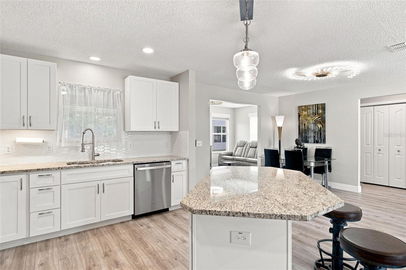 Granite countertops and a tile backsplash, both from 2024, complement the bright white cabinetry. - 2713 DE LA ROSA ST, THE VILLAGES