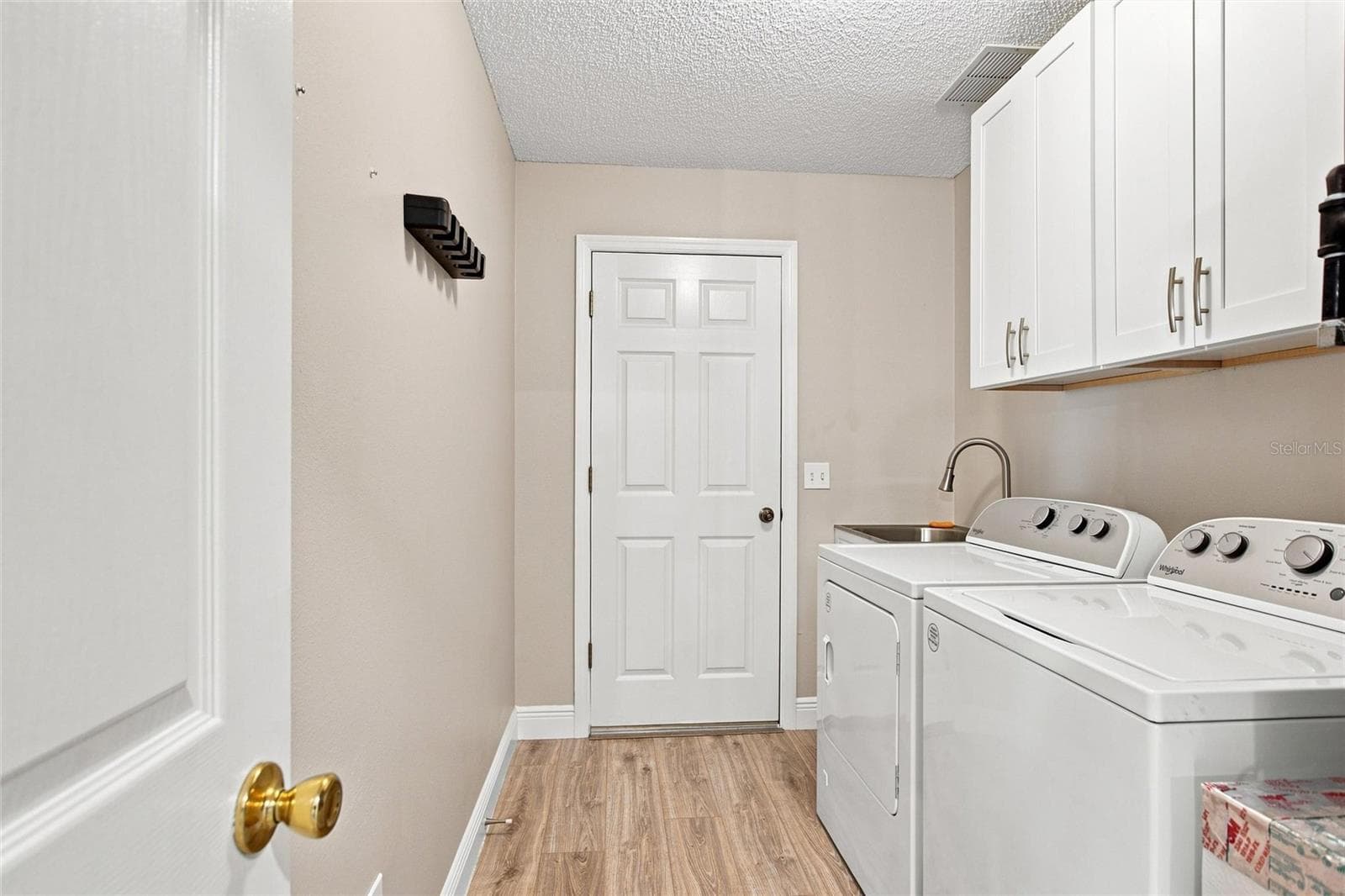 Indoor laundry with cabinets, utility sink and a 2024 Whirlpool washer and gas dryer. - 2713 DE LA ROSA ST, THE VILLAGES