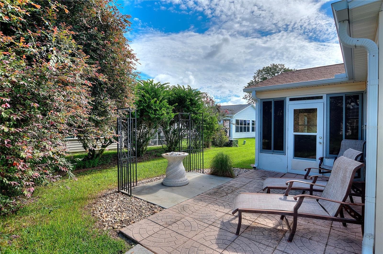 Established greenery adds a pleasant backdrop to the backyard sitting area. - 2713 DE LA ROSA ST, THE VILLAGES