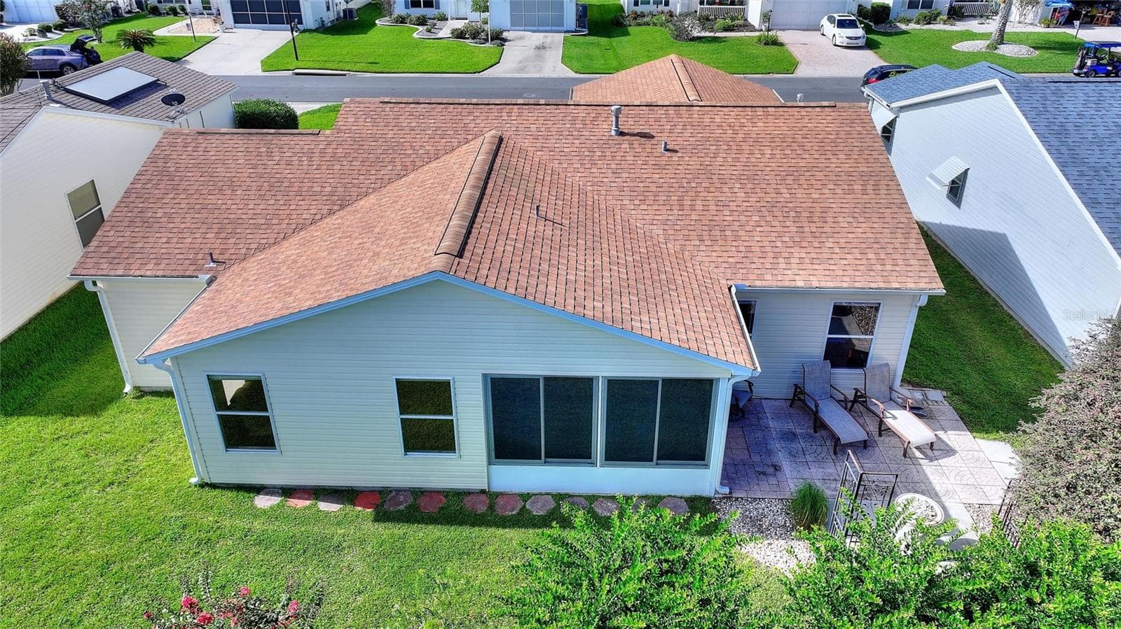 Elevated rear view shows the 2024 roof, enclosed lanai and adjoining outdoor patio. - 2713 DE LA ROSA ST, THE VILLAGES