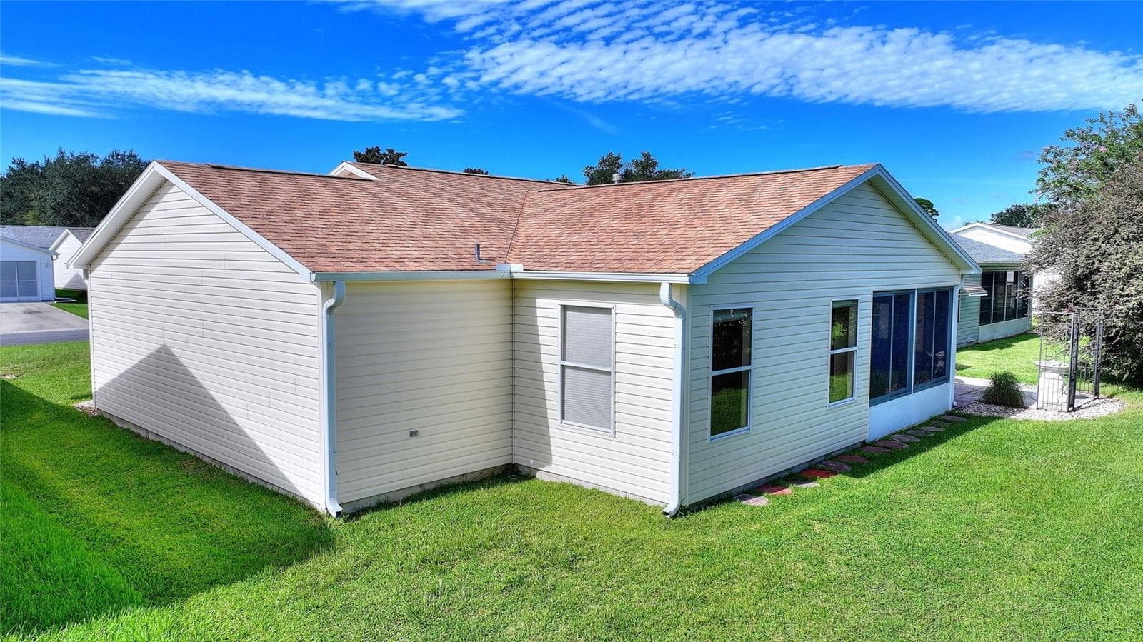 Lawn wraps around the rear of the home, with windows overlooking the yard. - 2713 DE LA ROSA ST, THE VILLAGES