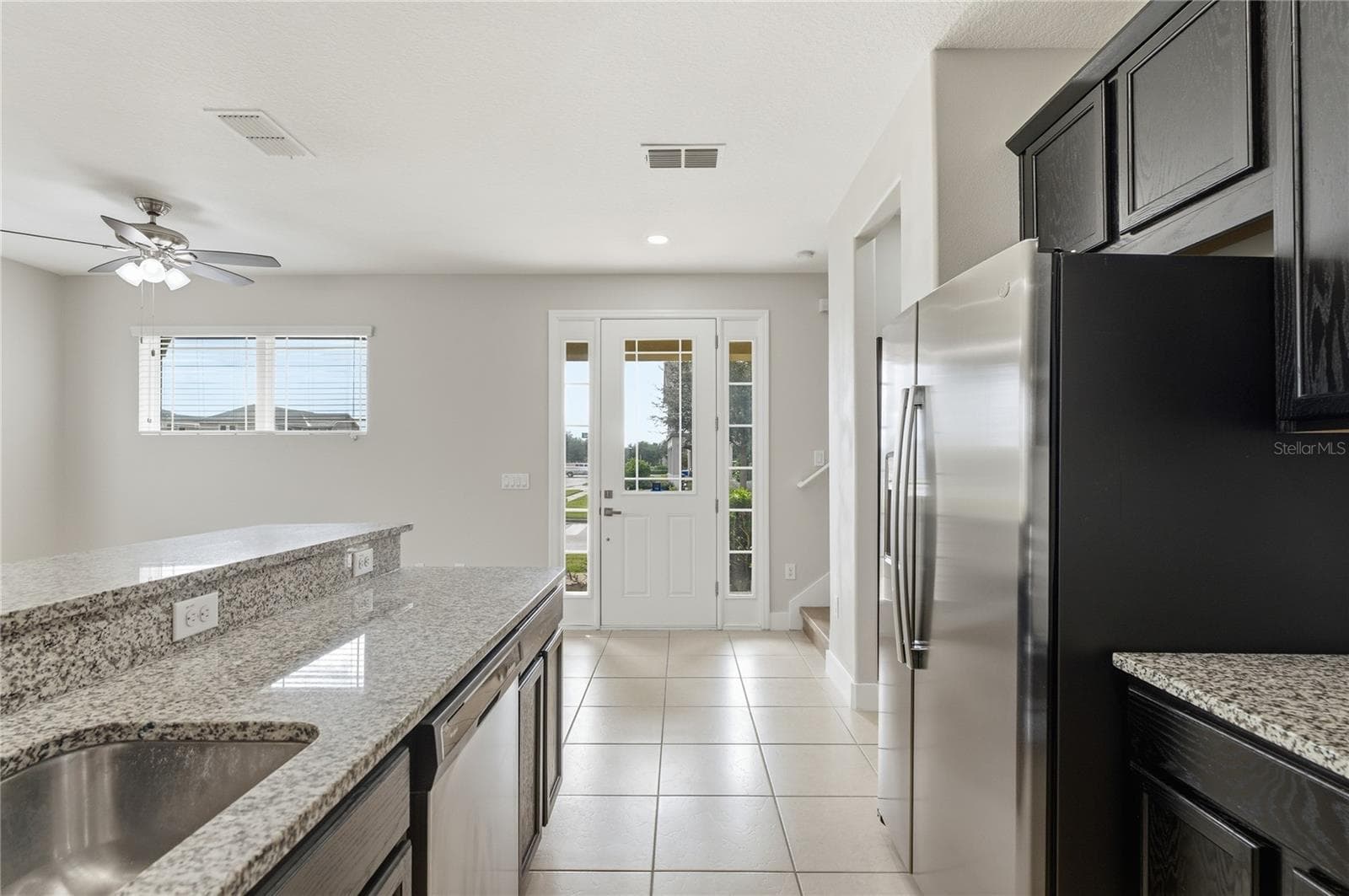 Bright open layout with an expansive granite breakfast bar and welcoming front entry. - 2615 GIARDINO LOOP, KISSIMMEE