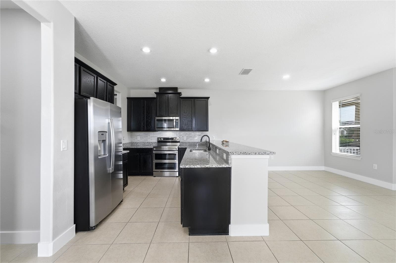 Spacious open-concept kitchen, dining and living areas with recessed LED lighting throughout. - 2615 GIARDINO LOOP, KISSIMMEE
