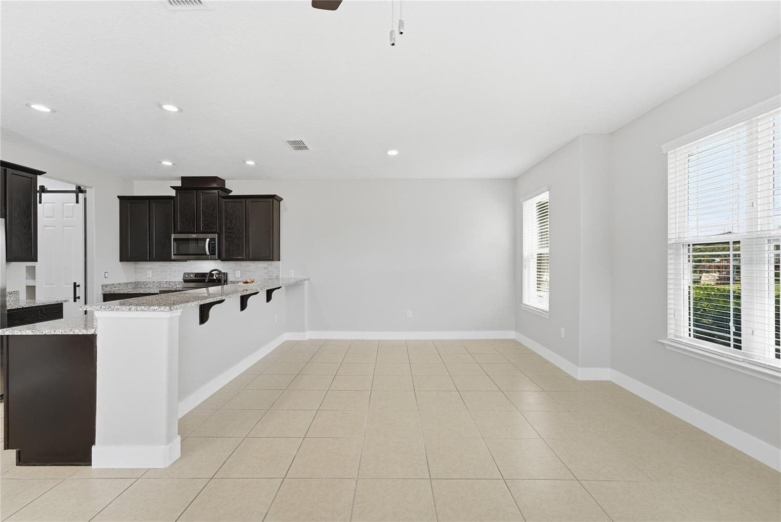 Spacious dining area with abundant natural light and seamless access to the kitchen. - 2615 GIARDINO LOOP, KISSIMMEE