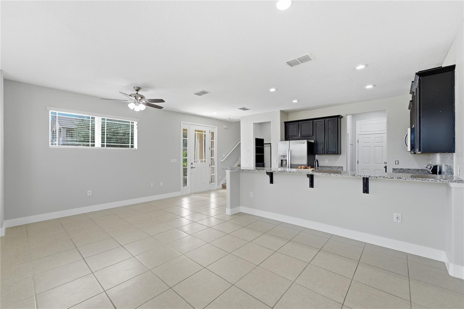 Bright and expansive open-concept living space with a generous breakfast bar and abundant natural light. - 2615 GIARDINO LOOP, KISSIMMEE