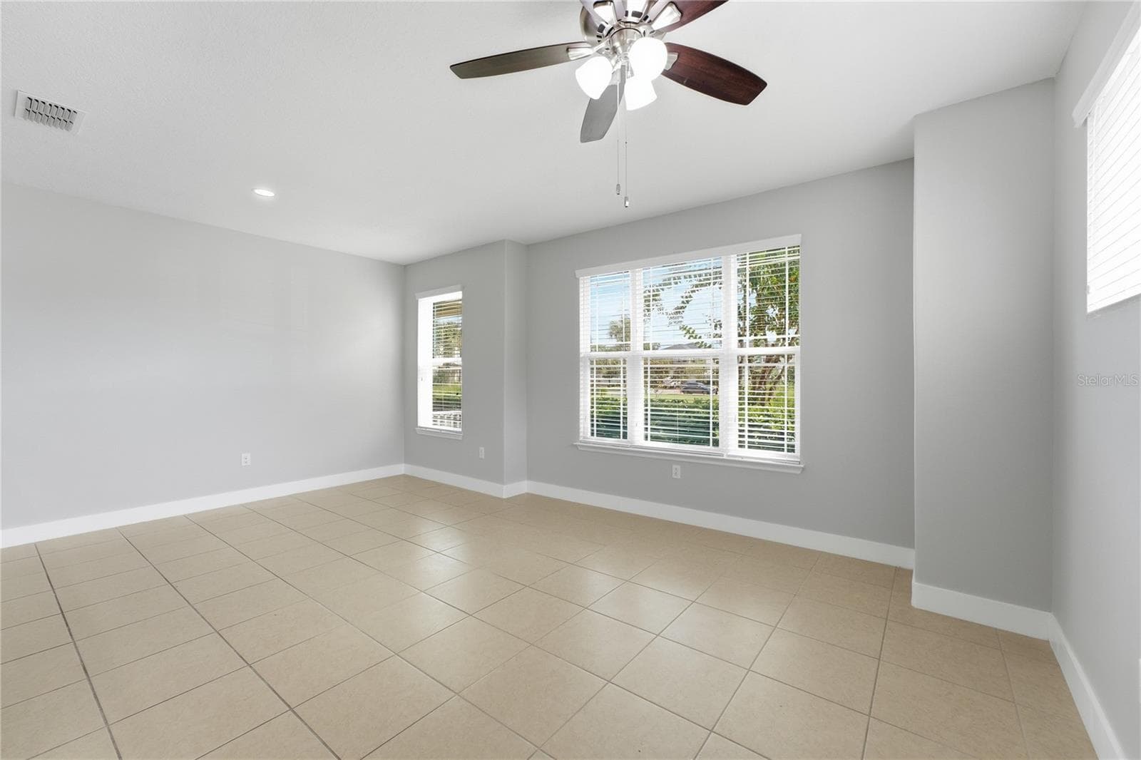 Spacious living and dining area filled with natural light from multiple windows. - 2615 GIARDINO LOOP, KISSIMMEE