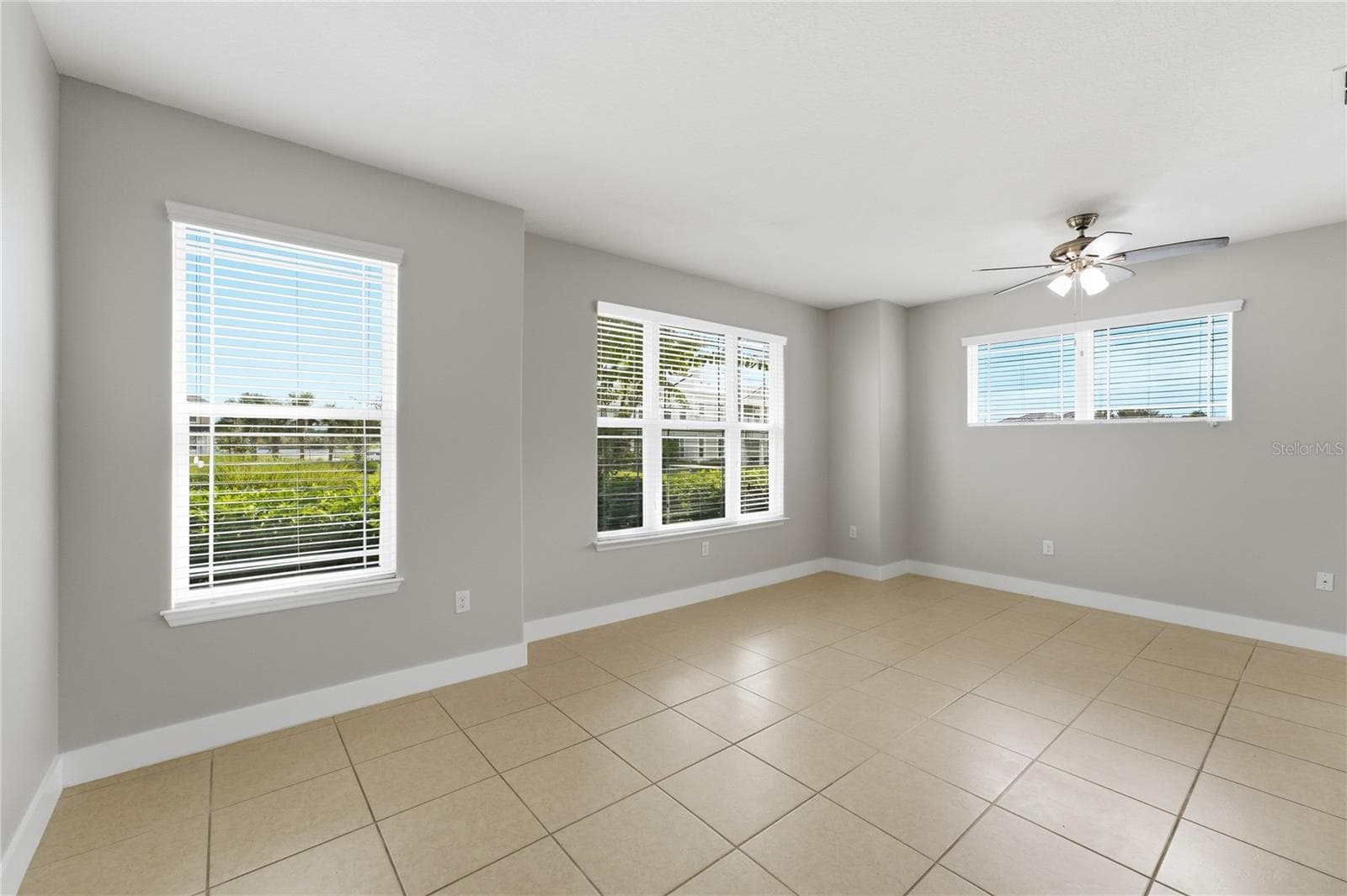 Spacious living and dining area with abundant natural light from multiple windows. - 2615 GIARDINO LOOP, KISSIMMEE