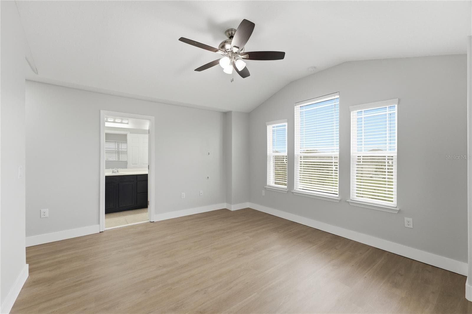 Spacious primary bedroom with abundant natural light and direct access to the en-suite bathroom. - 2615 GIARDINO LOOP, KISSIMMEE
