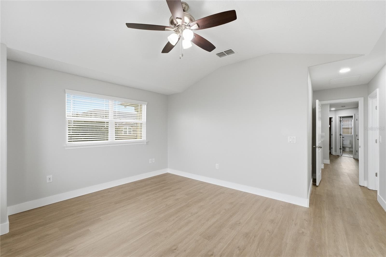 View from the spacious primary bedroom toward the hallway and secondary bedrooms. - 2615 GIARDINO LOOP, KISSIMMEE