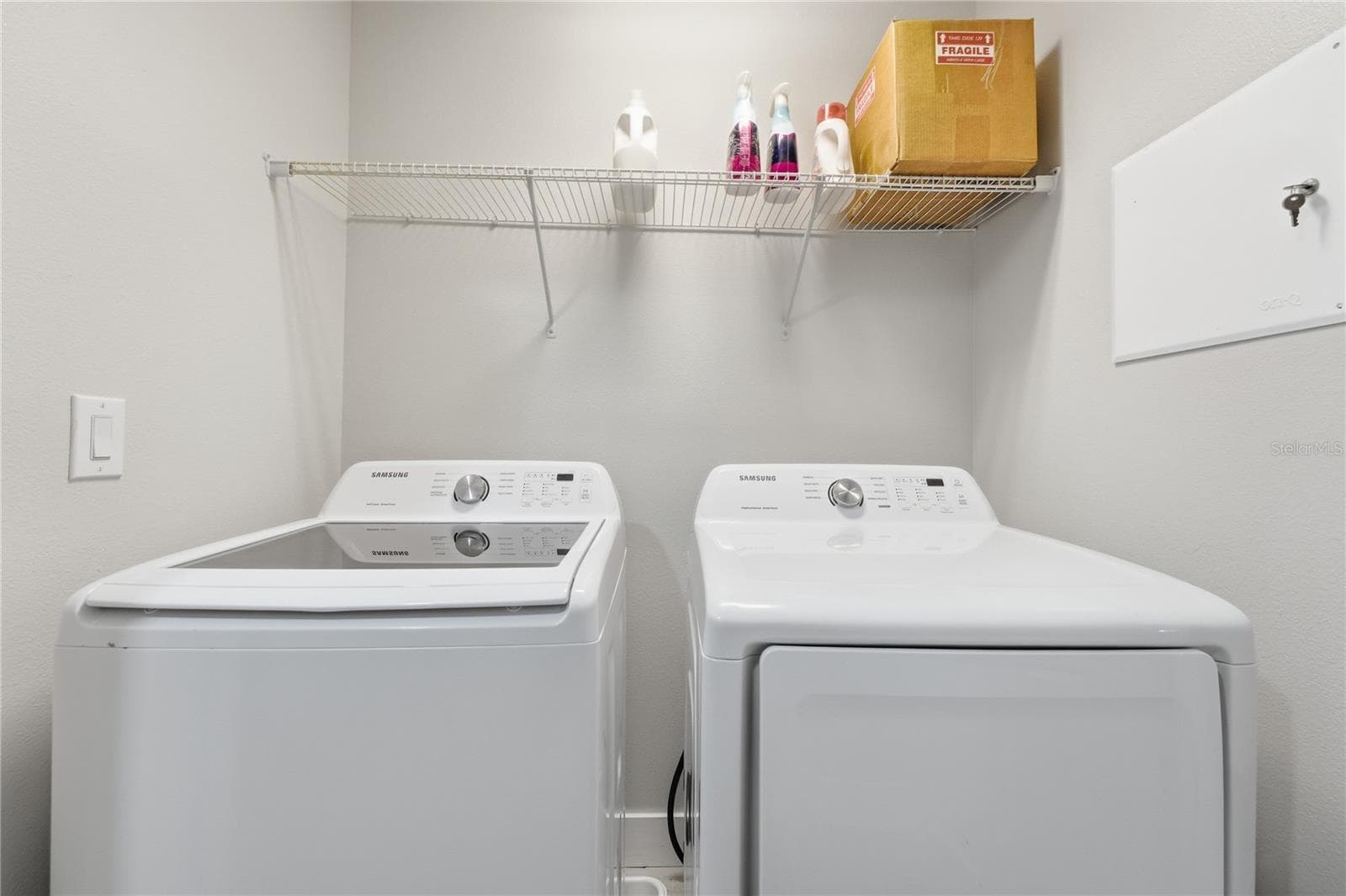 Convenient upstairs laundry room with full-size washer and dryer and overhead storage. - 2615 GIARDINO LOOP, KISSIMMEE