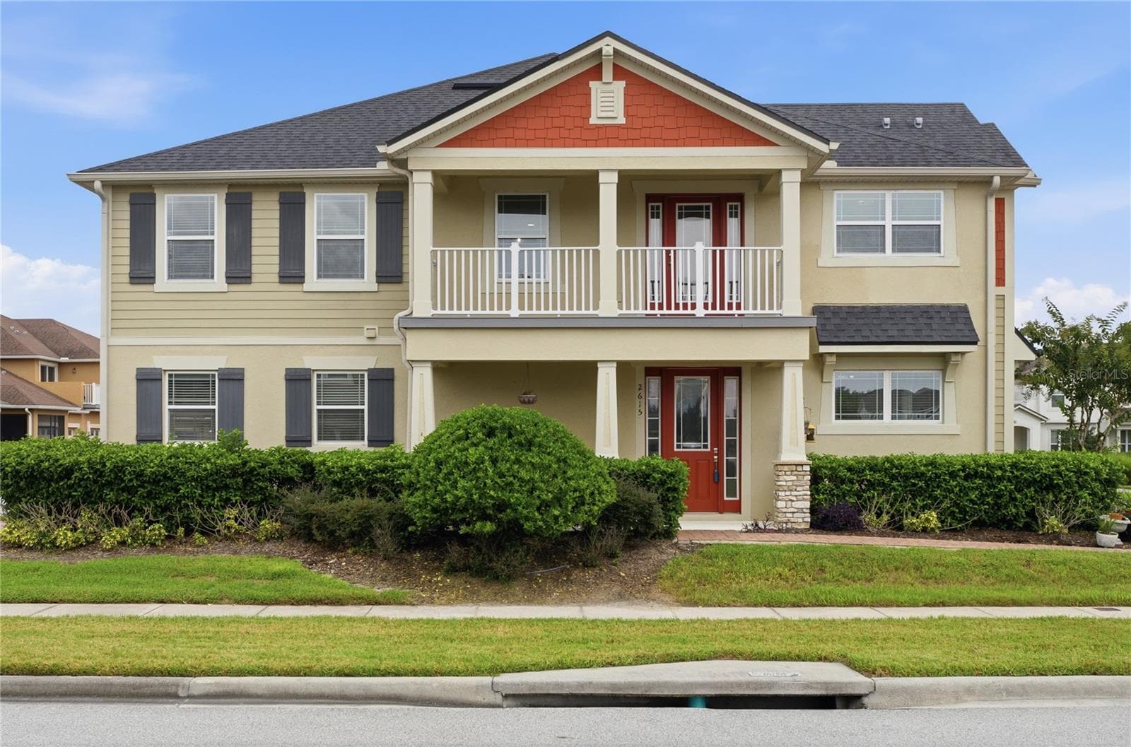 Impressive end-unit exterior featuring a covered front porch and spacious second-floor balcony. - 2615 GIARDINO LOOP, KISSIMMEE