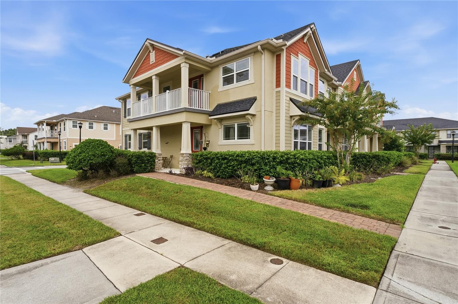 Charming end-unit exterior with a covered front porch, private balcony and additional side green space. - 2615 GIARDINO LOOP, KISSIMMEE