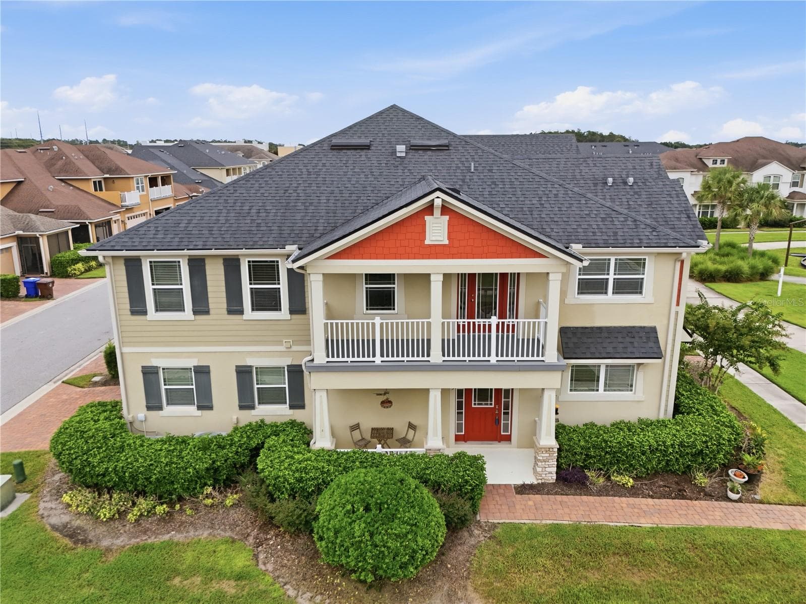 Striking end-unit exterior with a covered front porch, spacious upper balcony and lush landscaping. - 2615 GIARDINO LOOP, KISSIMMEE