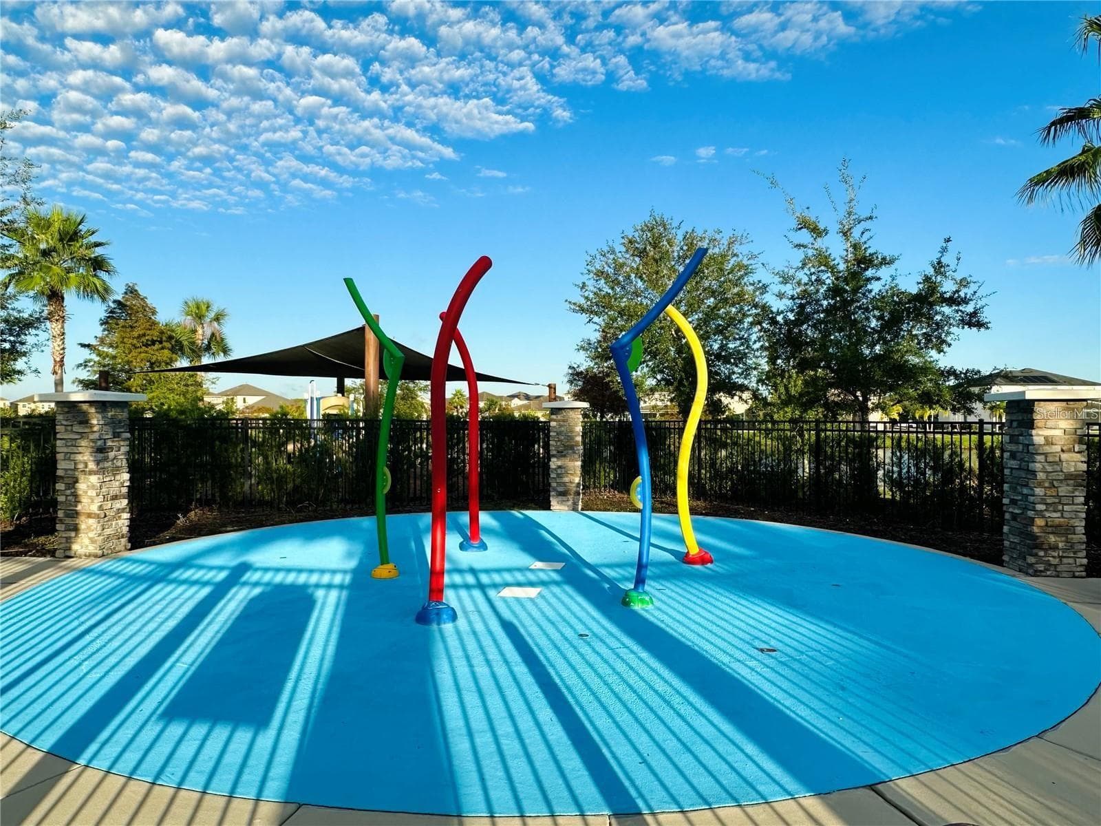 Colorful community splash pad with shaded seating nearby. - 2615 GIARDINO LOOP, KISSIMMEE