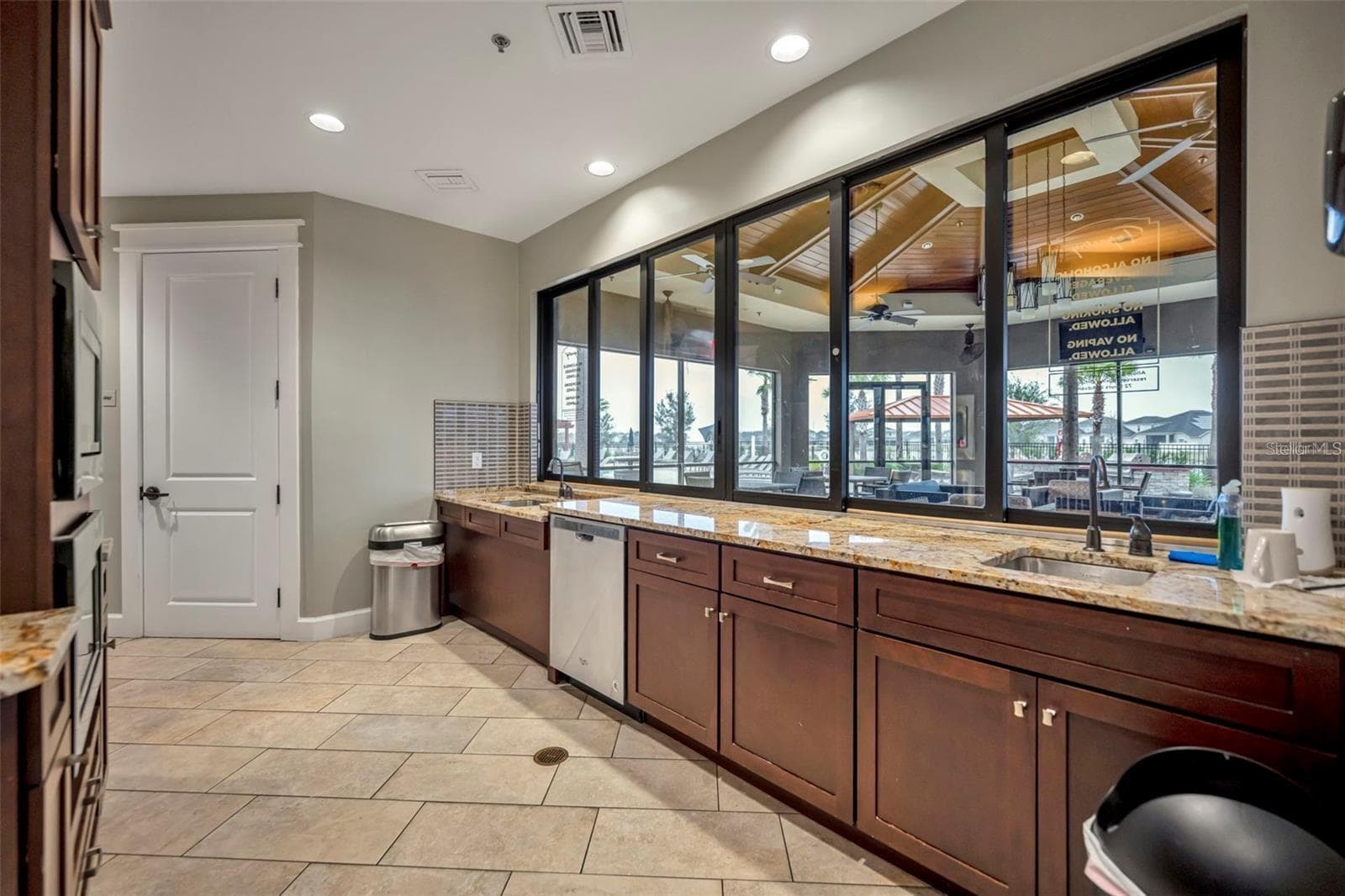 Clubhouse catering kitchen with granite countertops and direct access to the outdoor gathering area. - 2615 GIARDINO LOOP, KISSIMMEE