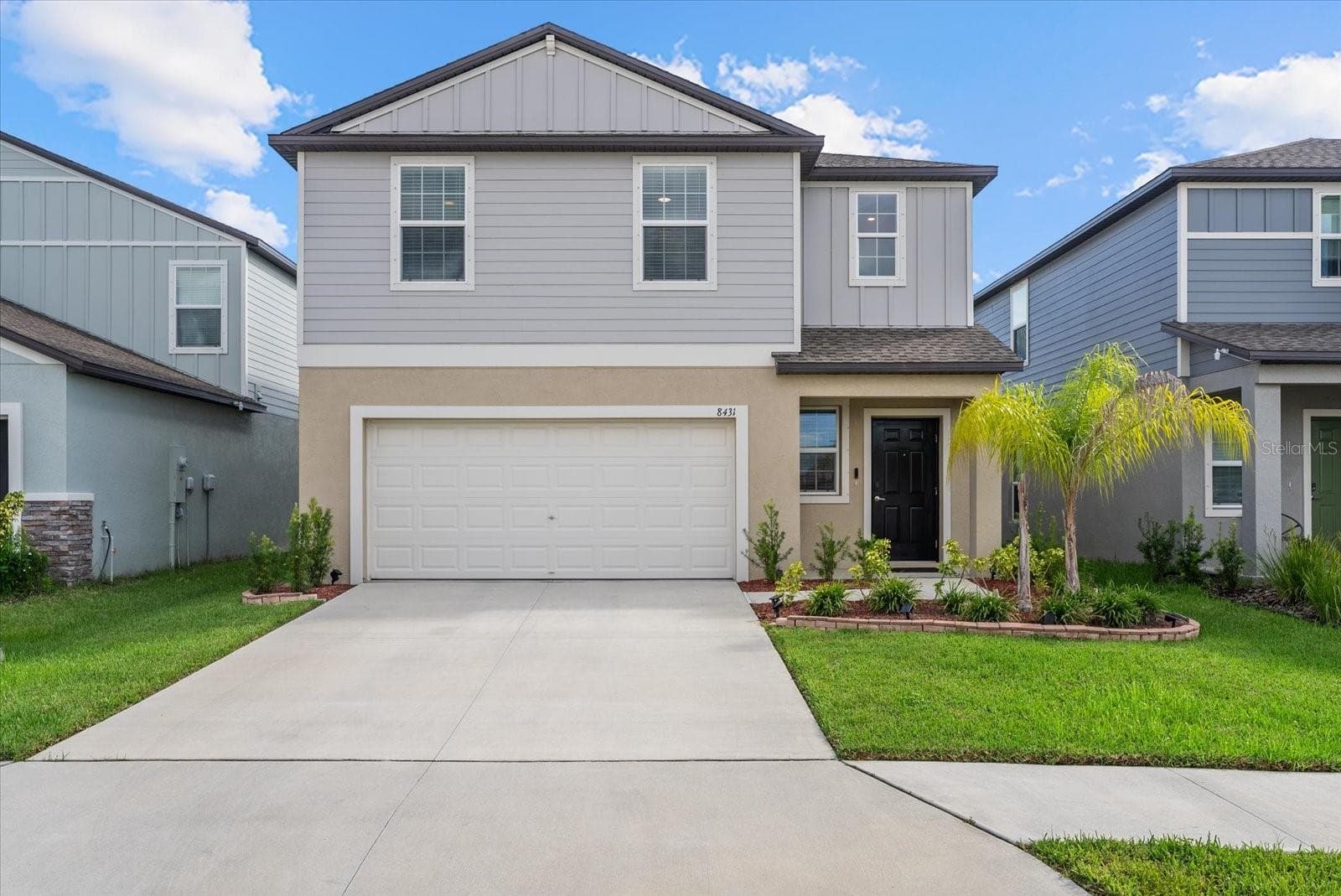 Beautiful front elevation enhanced by tropical landscaping and a well-maintained lawn. - 8431 BELLA MAR TRL, PARRISH