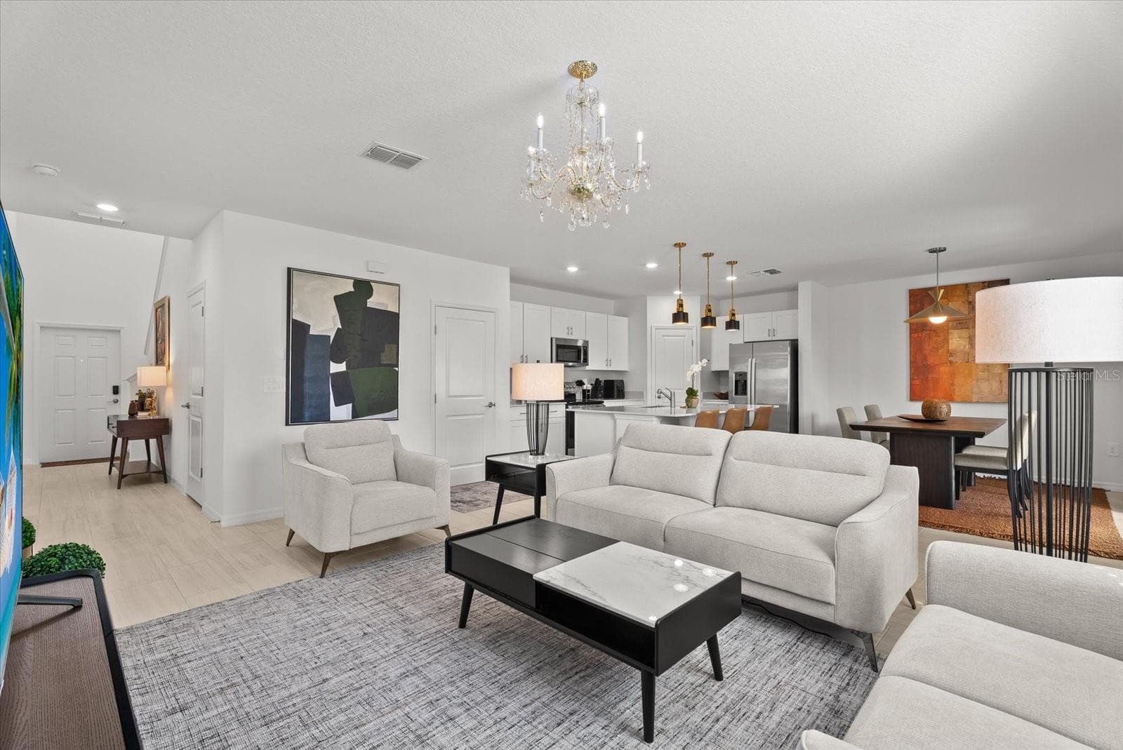 Open floor plan connecting the living room, kitchen, dining area, and foyer. - 8431 BELLA MAR TRL, PARRISH