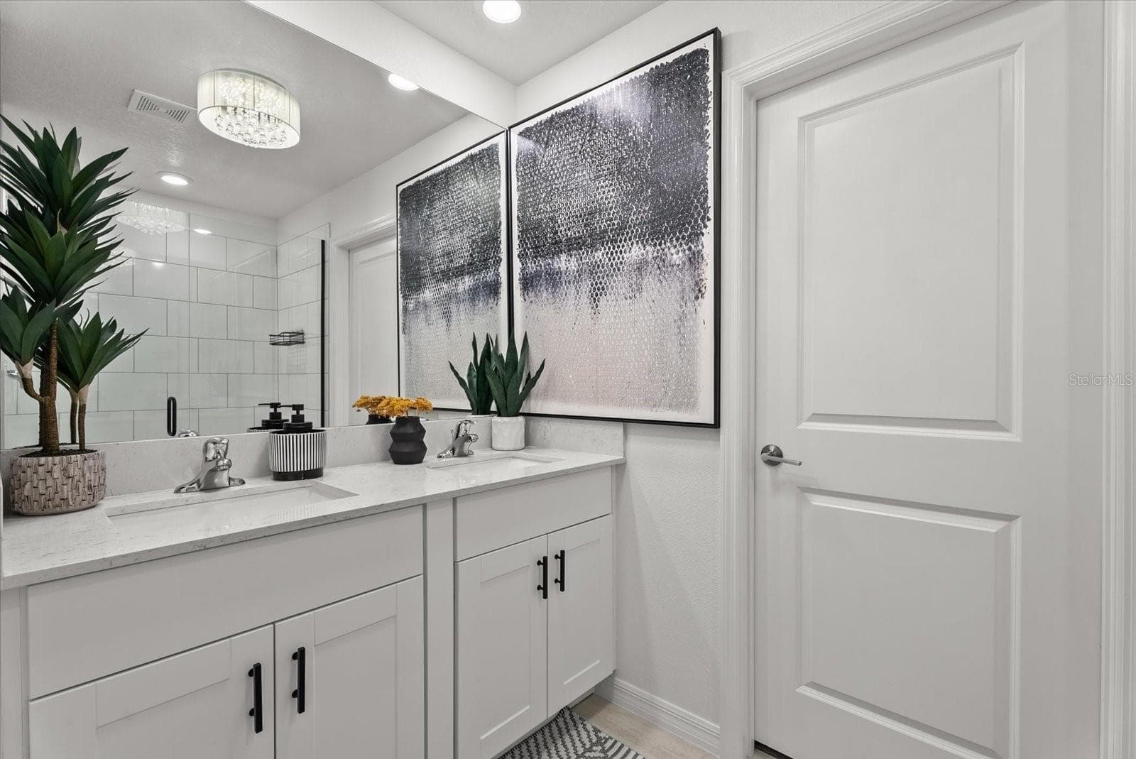 Primary bathroom featuring a double vanity, modern fixtures, and tiled shower. - 8431 BELLA MAR TRL, PARRISH