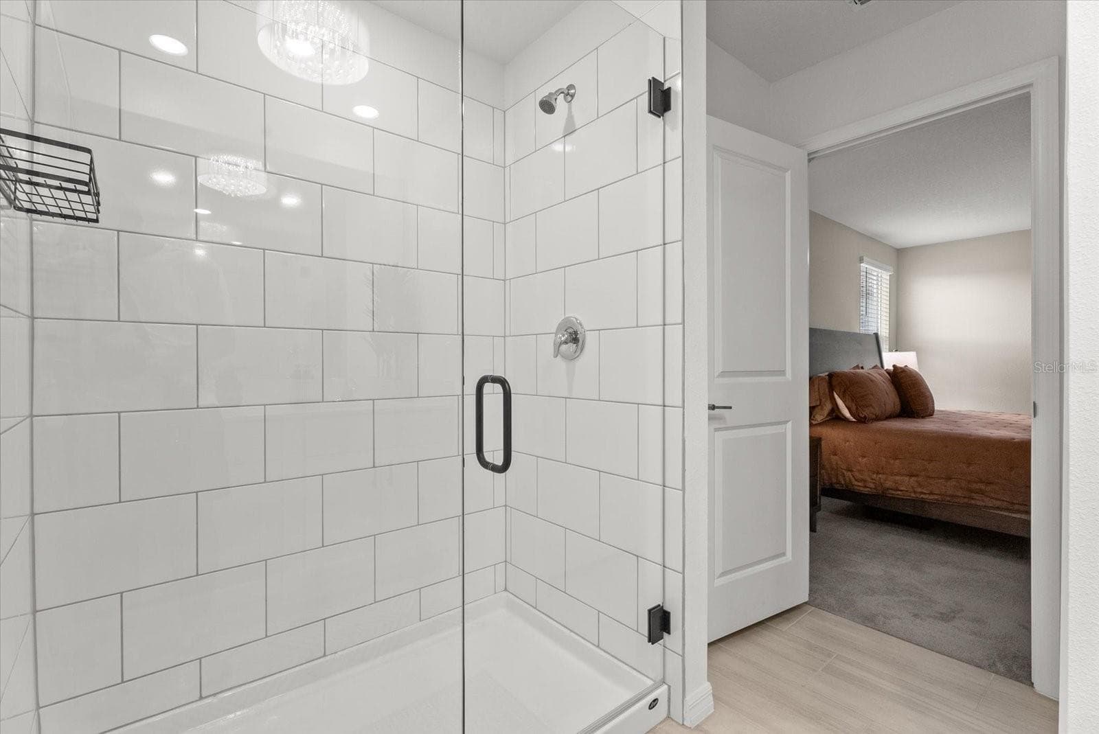 Primary bathroom featuring a tiled walk-in shower with a frameless glass door. - 8431 BELLA MAR TRL, PARRISH