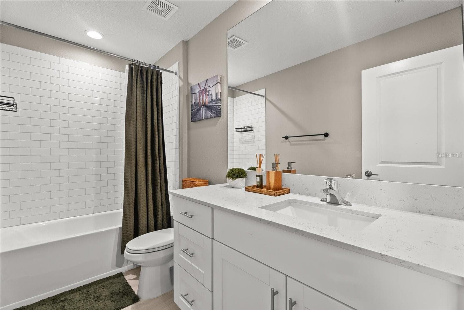 Full guest bathroom with a spacious vanity and tiled tub-and-shower combination. - 8431 BELLA MAR TRL, PARRISH