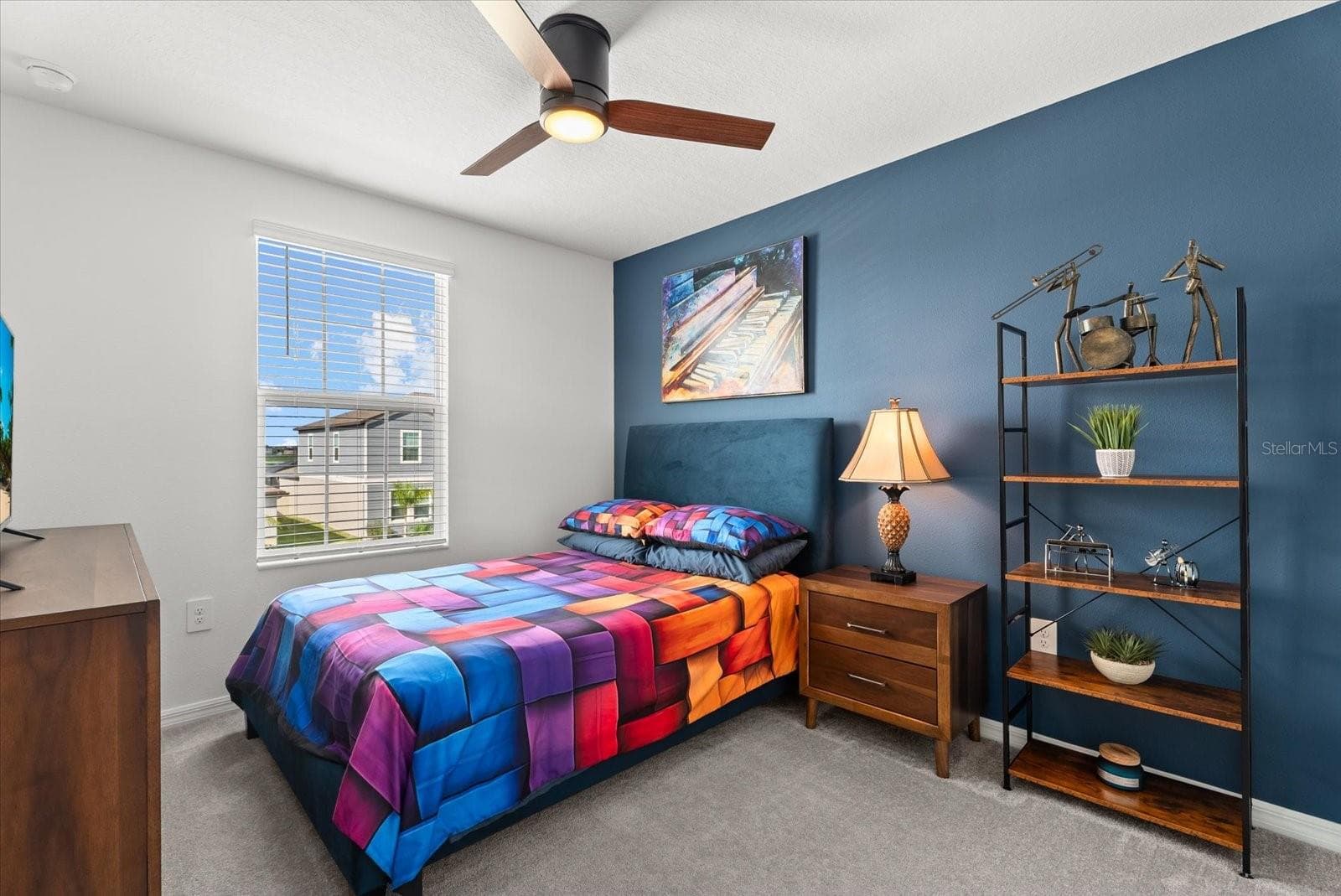 Additional bedroom featuring a ceiling fan, accent wall, and natural light. - 8431 BELLA MAR TRL, PARRISH
