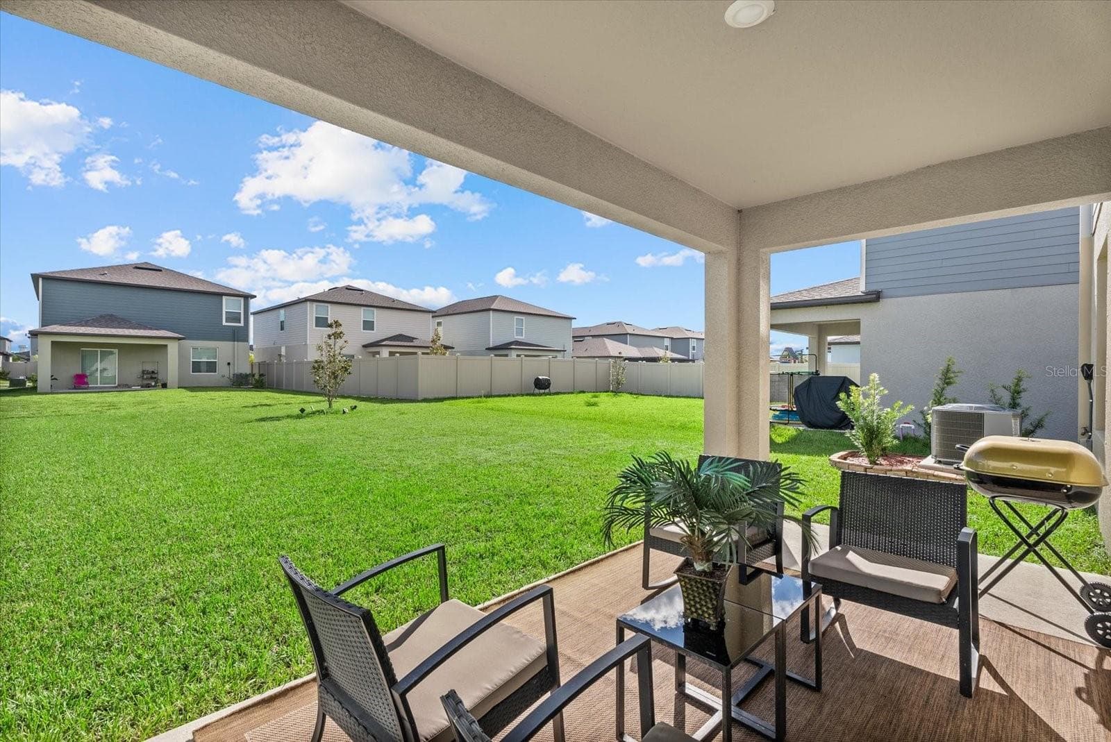 Covered rear patio overlooking the spacious backyard. - 8431 BELLA MAR TRL, PARRISH