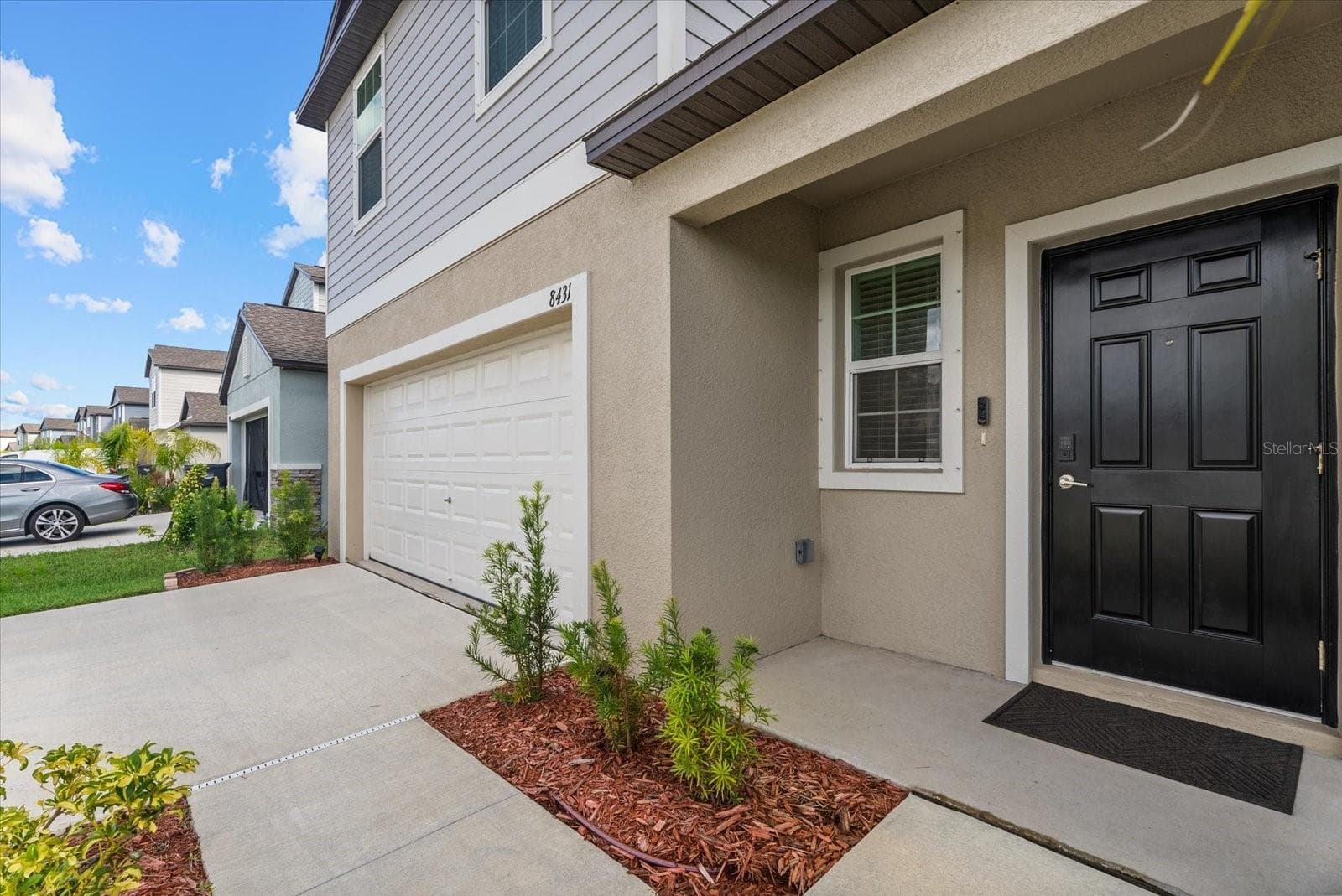 Welcoming covered entrance with a landscaped walkway and easy garage access. - 8431 BELLA MAR TRL, PARRISH