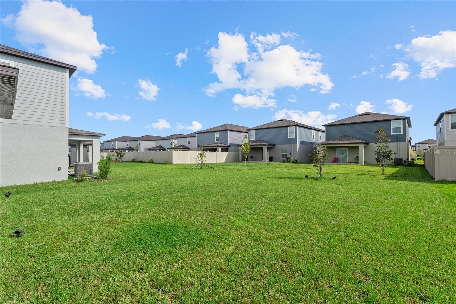Wide view of the open backyard and surrounding neighborhood. - 8431 BELLA MAR TRL, PARRISH