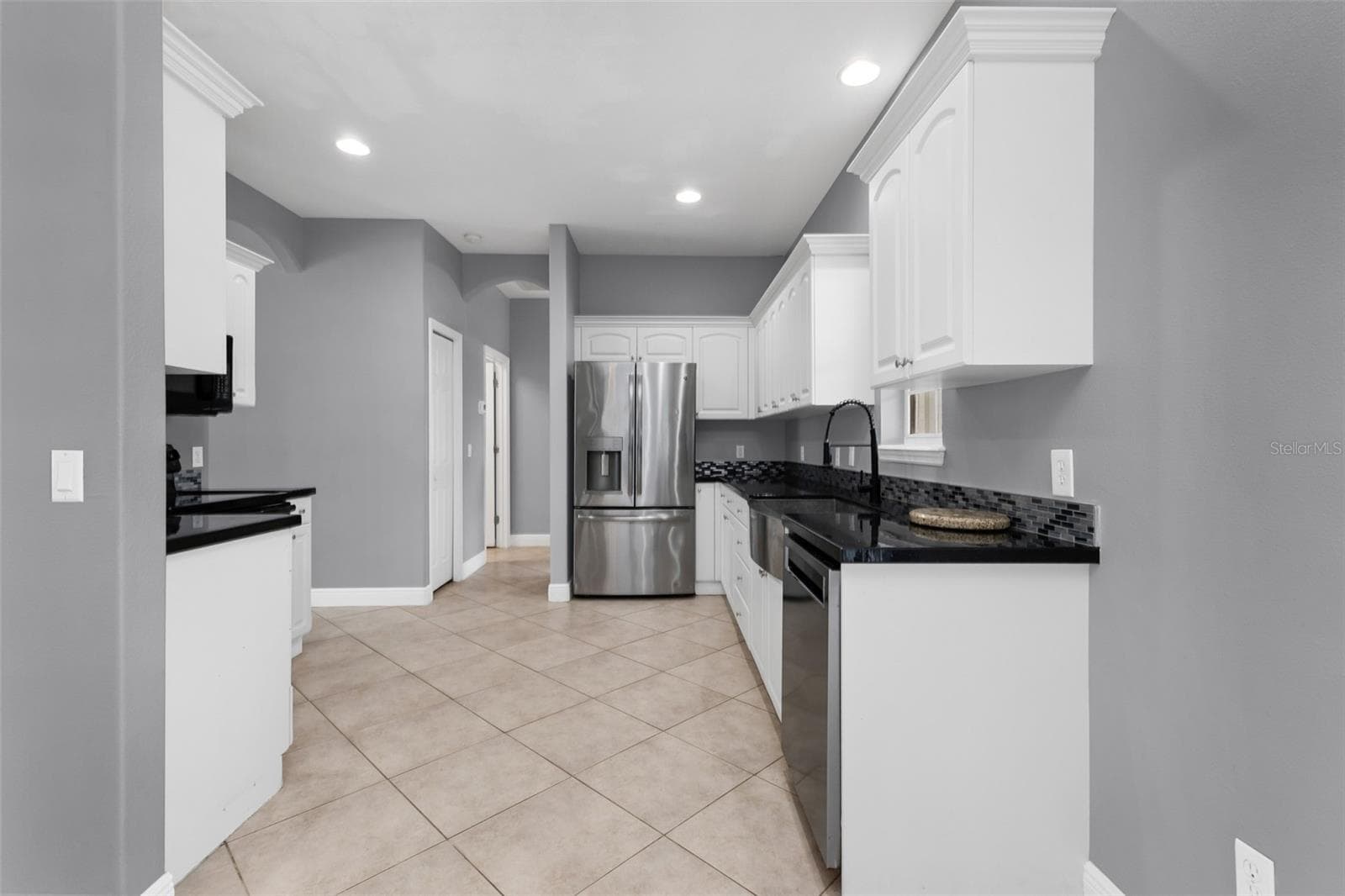 Kitchen features epoxy countertops, glass tile backsplash and plenty of cabinets. - 2739 ATWATER DR, NORTH PORT