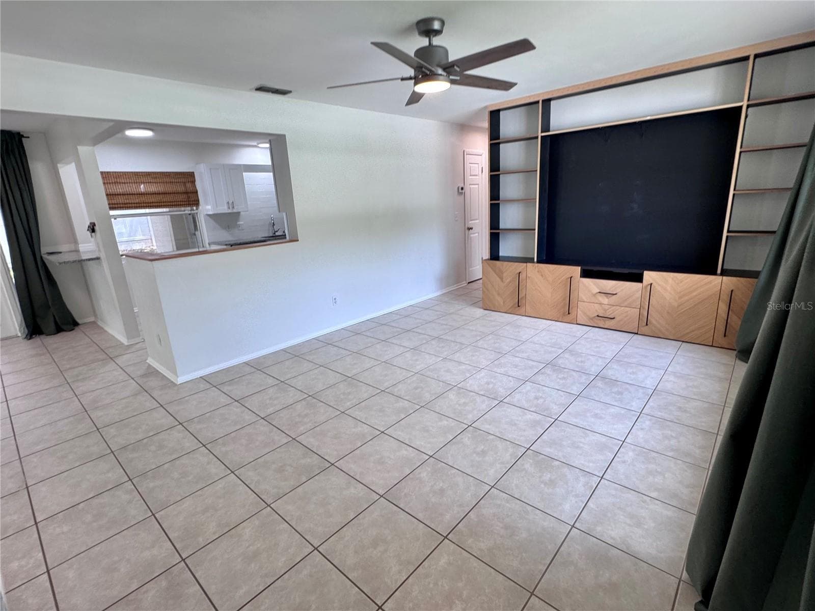 Living room with built in shelving and easy access to the kitchen breakfast bar - 1709 EATON DR NE, CLEARWATER